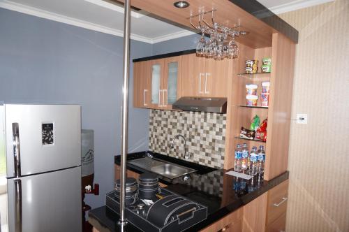 日惹萨法度假屋的一间带冰箱和炉灶的小厨房
