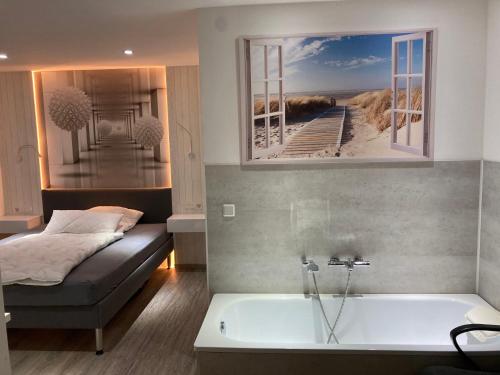 勒沃库森Messe-Hotelzimmer-Einzimmerappartement的一间卧室配有一张床和一个浴缸,享有海滩美景