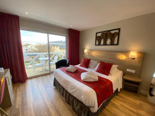 翁弗勒尔莫泰莱斯布鲁兹康泰克酒店的一间卧室设有一张床和一个大窗户
