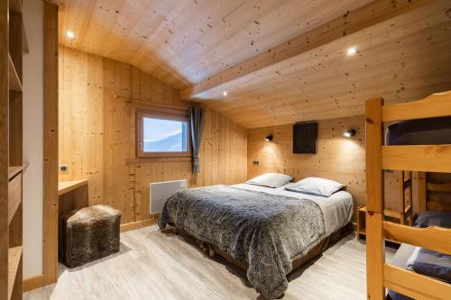 大博尔南Chalet Socali Le Grand Bornand的小木屋内一间卧室,配有一张床