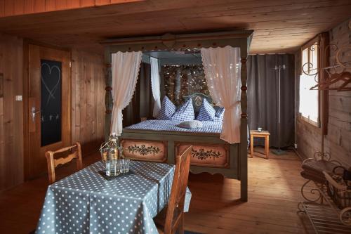 CuragliaNostalgie Bed & Breakfast Chrämerhus的一间卧室配有一张天蓬床和一张桌子及桌布