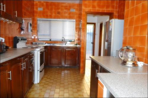 希伯丁Unit 6 Villa Marina的厨房配有木制橱柜和橙色墙壁