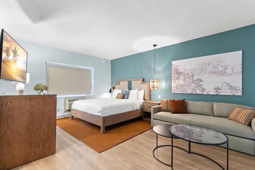 圣徒皮特海滩The Beachcomber St. Pete Beach Resort & Hotel的客厅配有床和沙发