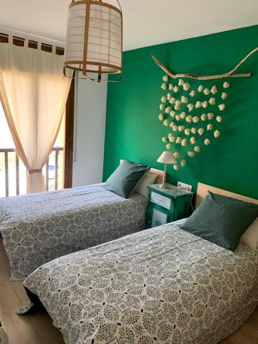 索特Apartament La Ruella的卧室设有两张床铺和绿色的墙壁