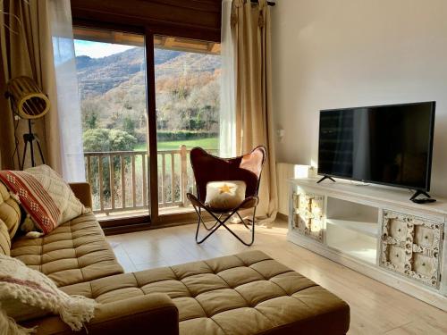索特Apartament La Ruella的带沙发和电视的客厅以及阳台。