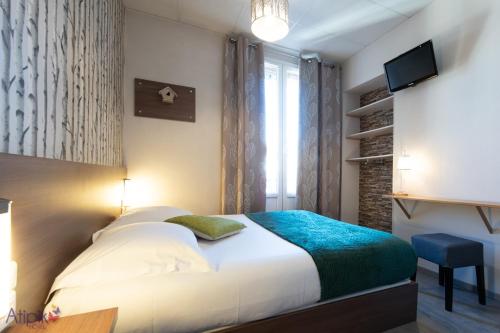 安锡Atipik Hôtel的一间卧室设有一张床、一台电视和一个窗口。
