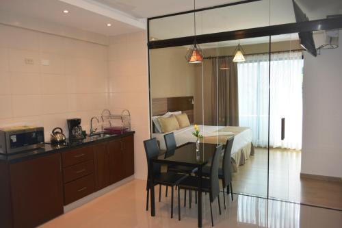 圣克鲁斯Premium Suites Deluxe Aparthotel Equipetrol的一间卧室设有餐桌和一张床