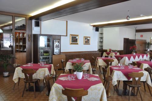 多比亚科多比亚科阿尔皮纳旅馆的餐厅设有红色和白色的桌椅
