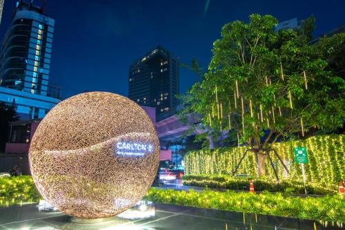 曼谷Carlton Hotel Bangkok Sukhumvit的灯火通明的树前的金球