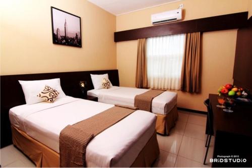 沙拉迪加彭多克鲁奥萨玛旅馆的酒店客房设有两张床和窗户。