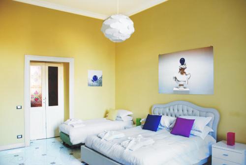 罗马比萨维托瑞欧87号膳宿旅馆的一间卧室设有两张床和黄色的墙壁