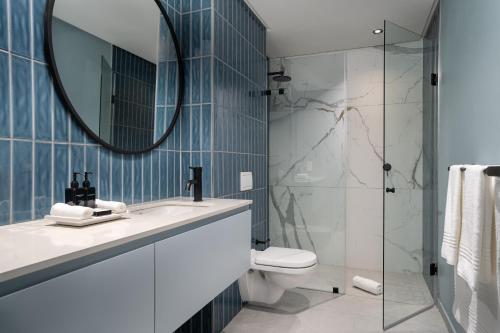 开普敦Home Suite Hotels De Waterkant的一间带水槽、卫生间和镜子的浴室