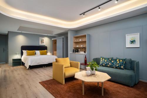 开普敦Home Suite Hotels De Waterkant的一间卧室配有一张床、一张沙发和一张桌子