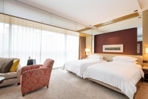 北京北京香格里拉的酒店客房,配有两张床和椅子