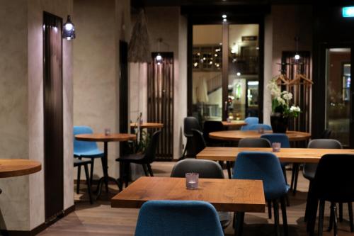 拉珀斯维尔-约纳雅各布酒店的餐厅设有木桌和蓝色椅子
