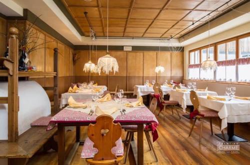 圣马蒂诺-迪卡斯特罗扎普拉戴拉纳萨酒店的餐厅设有白色的桌椅和吊灯。