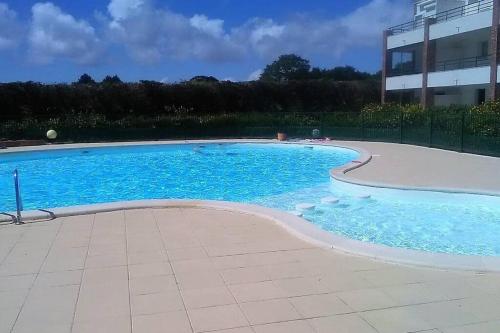 波尔尼克Studio - 700m plage port - 200m golf - wifi - piscine的大楼前的蓝色海水大型游泳池