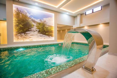 科帕奥尼克SREBRNA PLANINA Spa & Resort的一座房子里一个带瀑布的游泳池