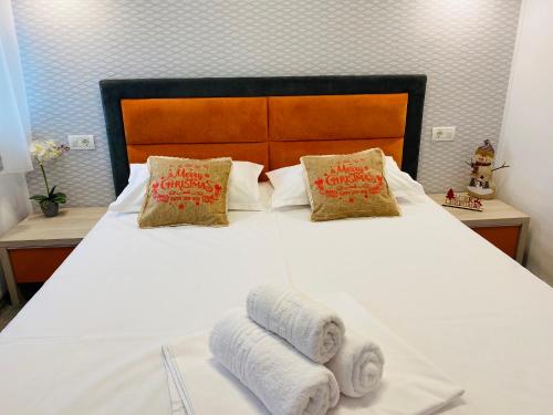 康斯坦察Orange House Constanta的卧室配有白色床和毛巾