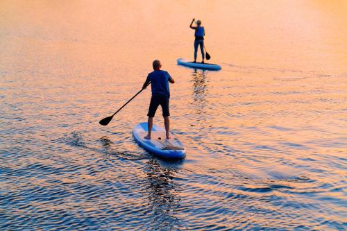 斯特拉特福德The Surfside Hotel的水中两人在桨板上