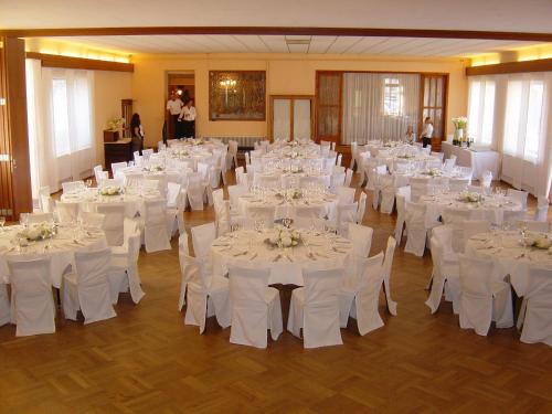 Sankt Christofen斯默释旅馆的宴会厅配有白色的桌子和白色的椅子