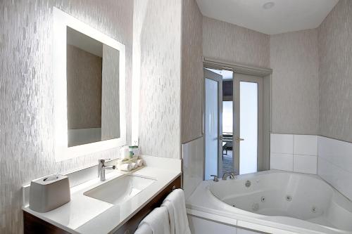 卡尔加里卡尔加里机场智选假日酒店的白色的浴室设有浴缸和水槽。