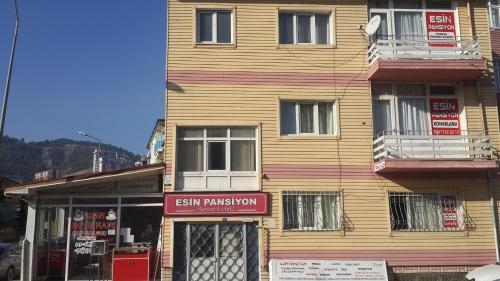 TokatEsin Pansiyon的一座木质建筑,前面有标志