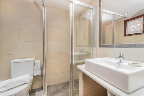 卡拉马孔Garden Village Studios & Apartments的一间带水槽、卫生间和淋浴的浴室