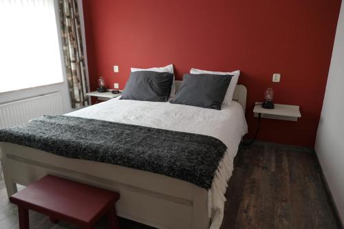 DaarleErve Eshuus Daarle的一间卧室设有一张红色墙壁的大床