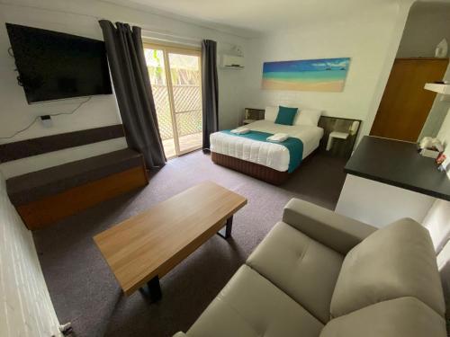 纳鲁马陶坡唐汽车旅馆的酒店客房,配有床和沙发