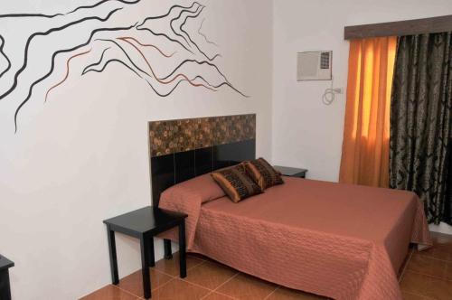 安蒂波洛佳期美食度假酒店的一间卧室配有一张壁画床
