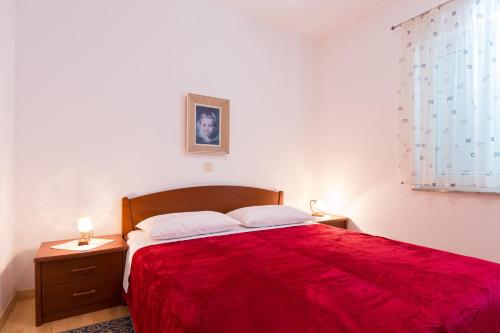 克尔克Apartman Leana的一间卧室配有一张红色大床和2个床头柜