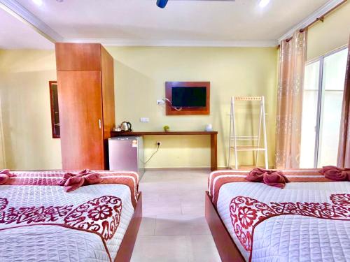 珍南海滩Norshah Village Resort的一间酒店客房,设有两张床和电视