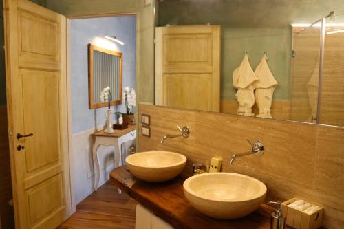 皮恩扎Il Mastio di Spedaletto的一间带两个盥洗盆和大镜子的浴室