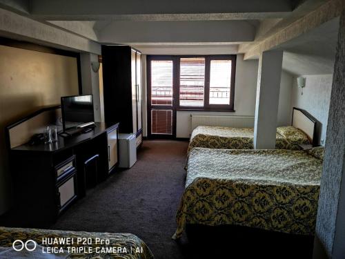 斯莫梁Ribkata Family Hotel的酒店客房设有两张床和电视。