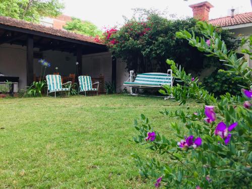 埃斯特角城圣雷莫蓬酒店 的一个带长凳、椅子和鲜花的院子
