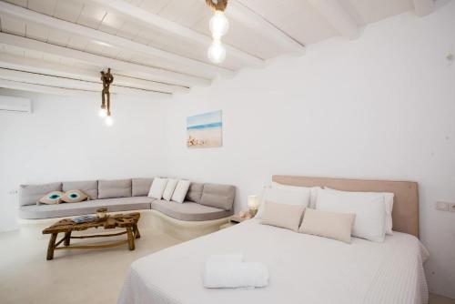 胡拉吉亚Gorgeous Studio In Cycladic Architecture Overlooking The Aegean的白色卧室配有床和沙发