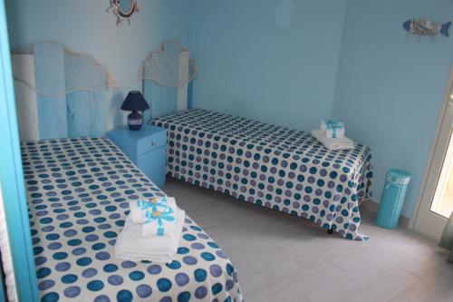 雷阿尔蒙特Maré - Scala dei Turchi的蓝色墙壁客房中的两张单人床