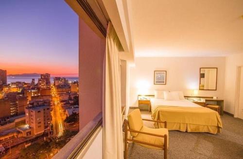 Puerto La CruzHotel Cristina Suites的酒店客房享有城市美景,配有一张床。