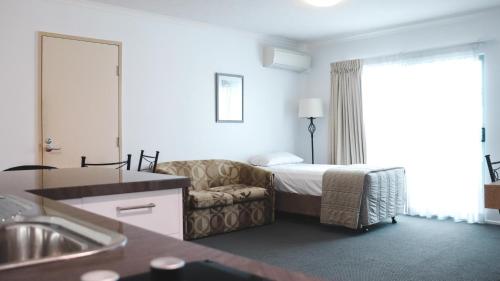 凯恩斯Heritage Cairns Hotel的酒店客房,配有床和沙发