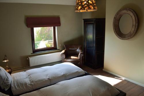 布鲁塞尔玫瑰伏尔泰别墅酒店的卧室配有床、椅子和窗户。