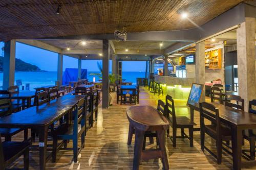 哈林海滩Sunrise Resort- Koh Phangan - SHA Extra Plus的一间带桌椅的海景餐厅