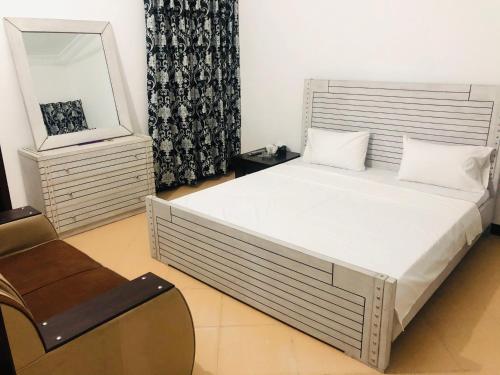 伊斯兰堡Lux Lounge Guest House的一间卧室配有一张床、镜子和椅子