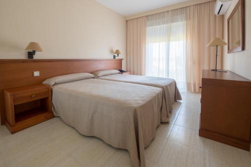 奇克拉纳－德拉弗龙特拉沙丘公寓式酒店的酒店客房设有床和窗户。