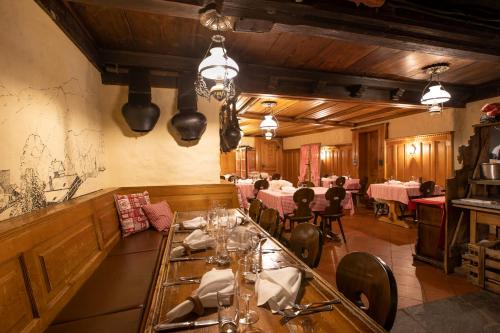 GsteigHotel Bären的一间在房间内配有桌椅的餐厅