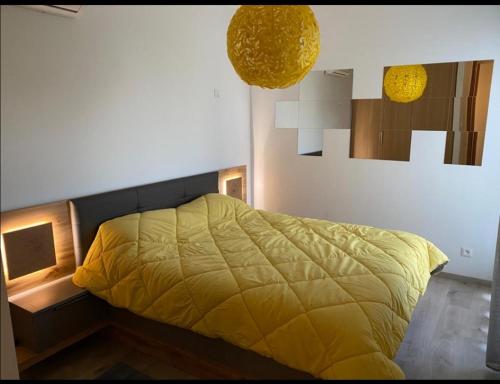 布兹尼盖Appt Bouznika EDEN ISLAND pied sur Mer的一间卧室配有一张黄色棉被的床