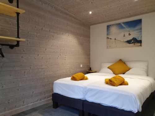 谷雪维尔Lodge Les Merisiers的一间卧室配有两张带黄色枕头的床。