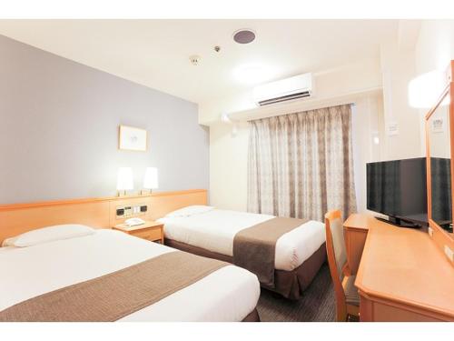 和歌山和歌山县微笑酒店的酒店客房设有两张床和一台平面电视。