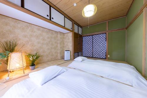 富士河口湖Villa RAKUWA Bettei的一间卧室配有两张床和椅子