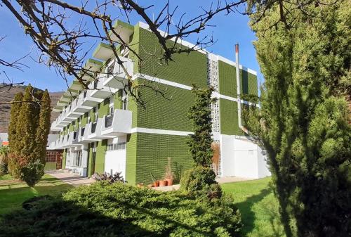 仕格莱Hotel del Trueno的绿色和白色的建筑,有院子